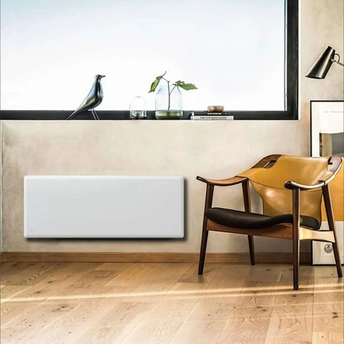 Radiatore elettrico a convezione Klimago™ NOBO TOP bianco installato a parete in un soggiorno moderno e luminoso.