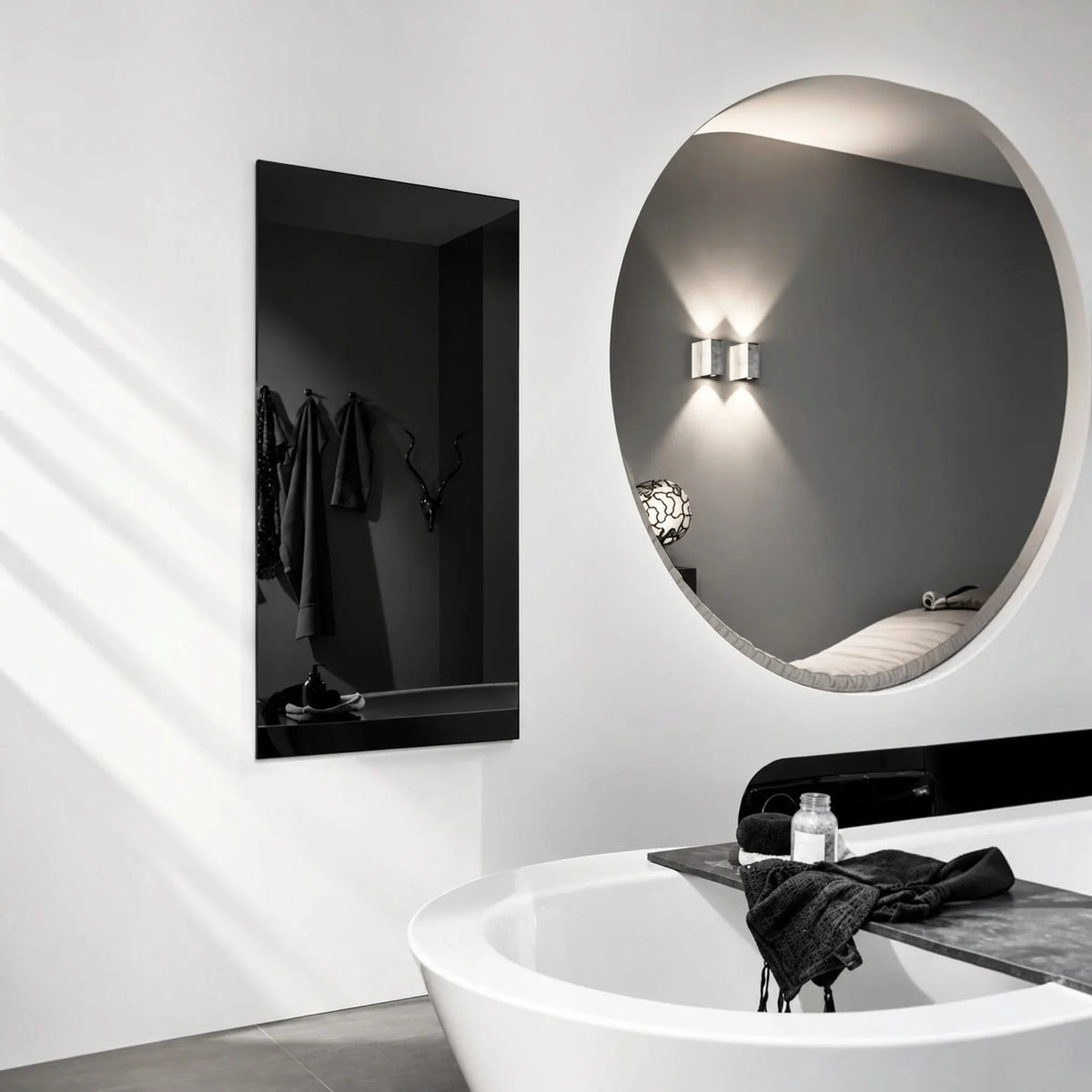 Pannello radiante a infrarossi Klimago™ Glass Line nero installato a parete in un bagno moderno con vasca