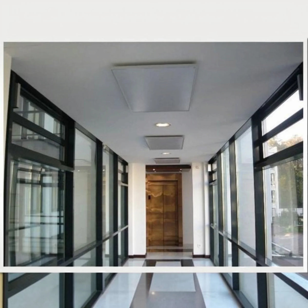 Pannello radiante a infrarossi da soffitto Klimago™ Standard Line bianco installato in un corridoio moderno